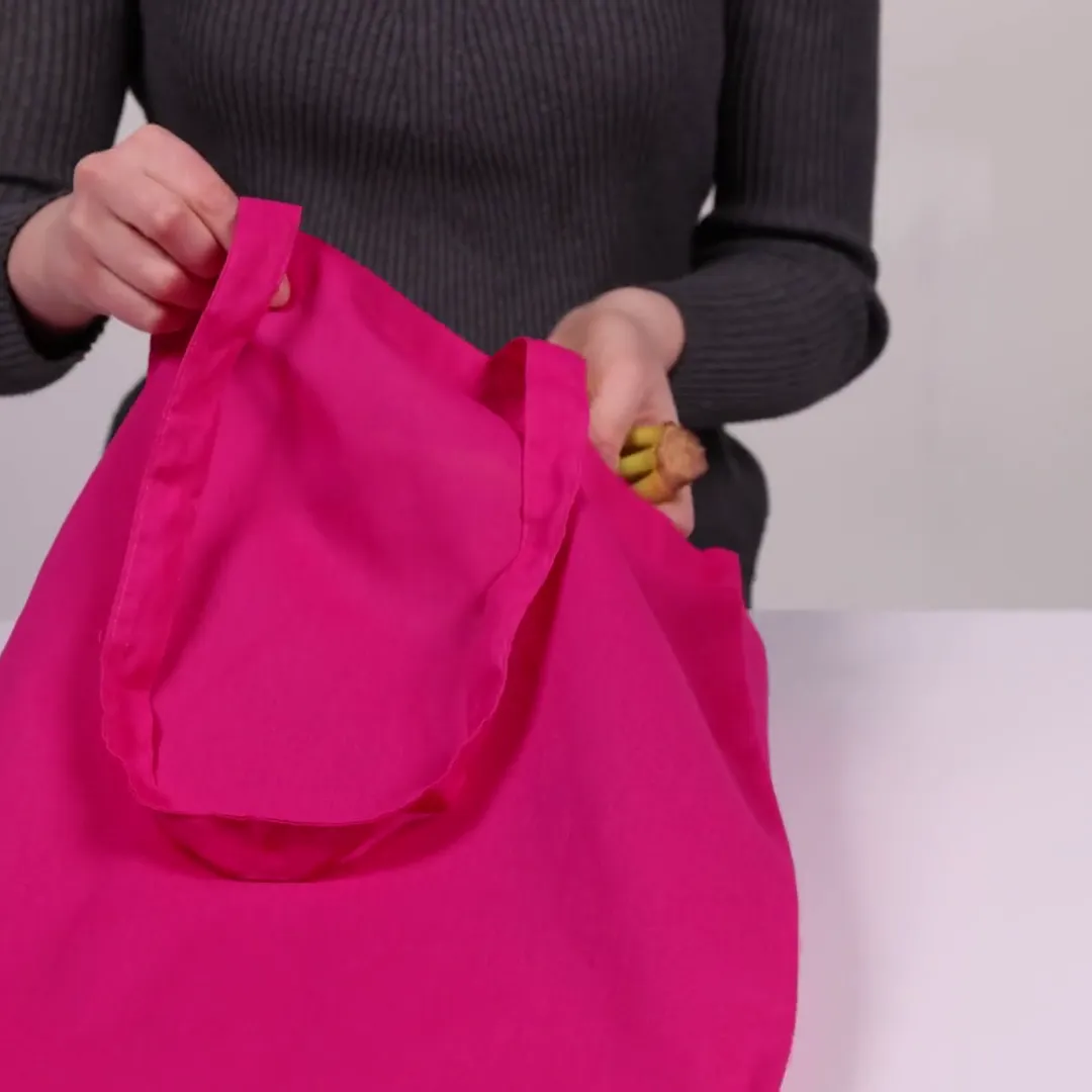 Bomuldspose, 140 g/m², vist af en person i produktvideoen – magenta