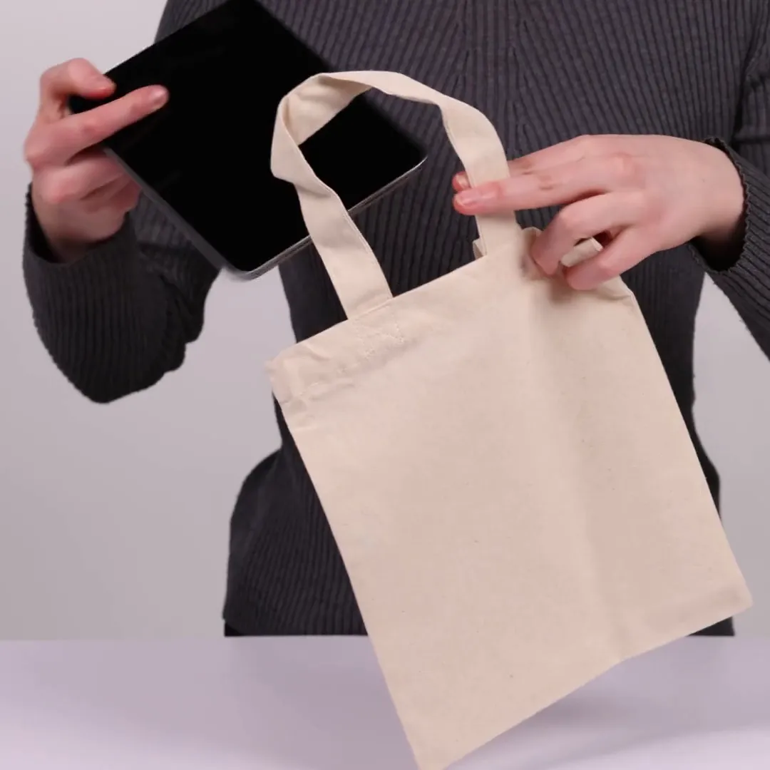 Bomuldspose, 22 × 26 cm, vist af en person i produktvideoen – natur