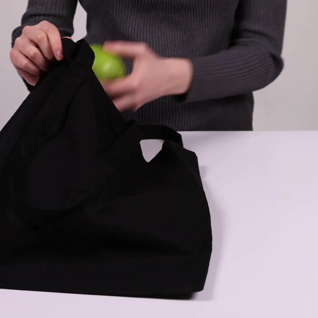Bomuldspose, 220 g/m², holdt af en person – sort
