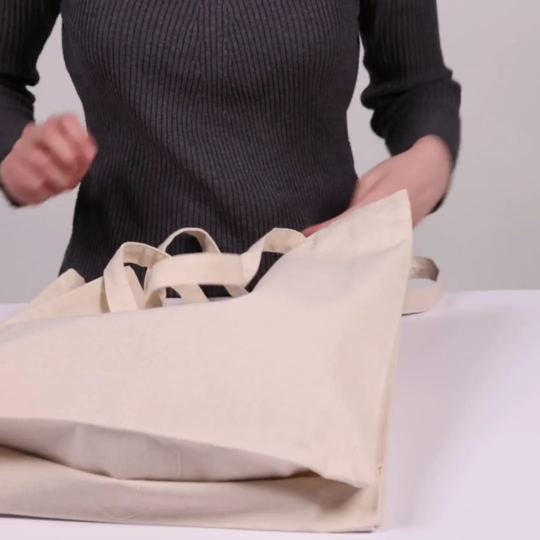 Bomuldspose med fals, 220 g/m², vist af en person i produktvideoen – natur