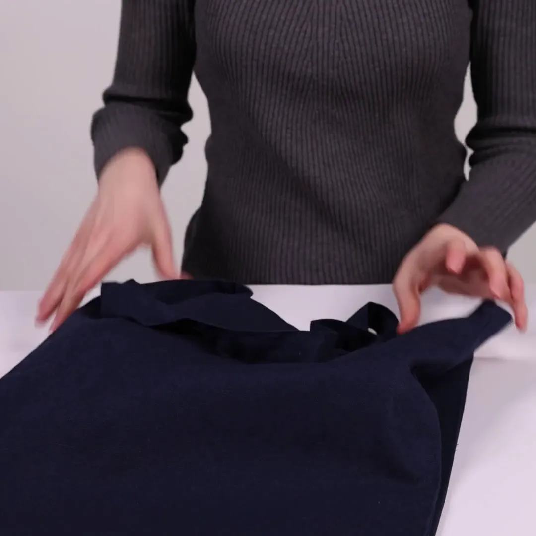 Bomuldspose med fals, 220 g/m², vist af en person i produktvideoen – sort