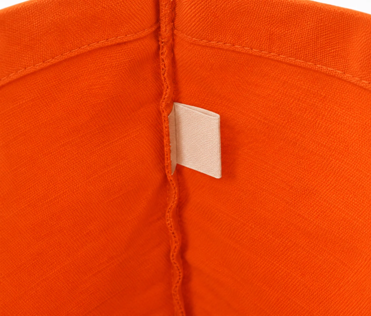 Økologisk bomuldspose, 30 × 35 cm, nærbillede af etiketten på indersiden – orange